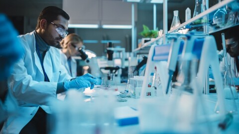Healthcare professionals working in a modern laboratory environment with advanced medical and research equipment.